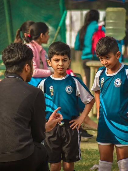 A coach gives instructions to two young players during a break in a Pride Cup match.