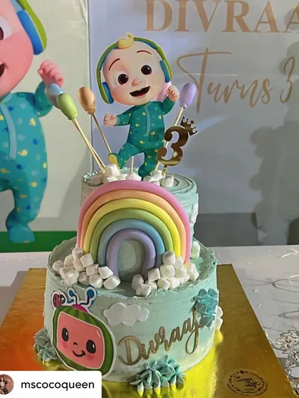A fantastic two-tier Cocomelon cake for Divraaj's third birthday. The cake features a rainbow and the main character, JJ, perfectly matching the party's theme.