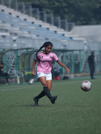 A player controlling the ball with a deft touch, ready to make her next move.