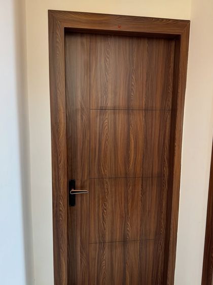A modern wooden flush door used throughout the 2BHK apartment.
