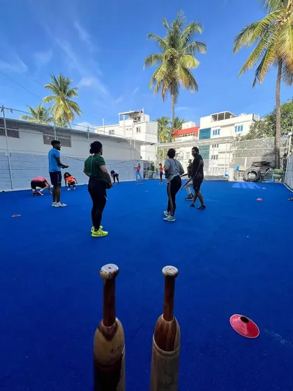 A group trains on our bright blue turf under a clear sky. This image showcases our vibrant, open-air training environment, a refreshing alternative to a typical gym.