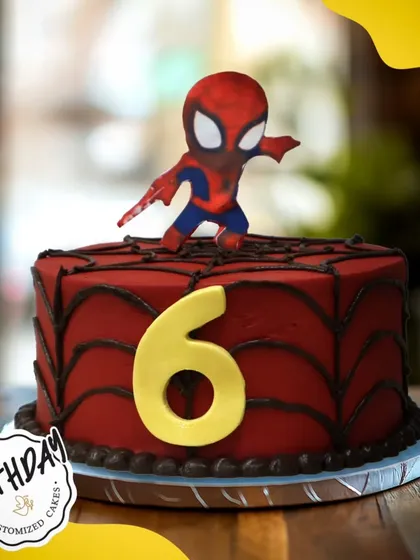 A fun Spider-Man cake for a 6th birthday. This design features a cute, stylized Spidey on top of a red web-covered cake, perfect for a younger fan of the web-slinger.
