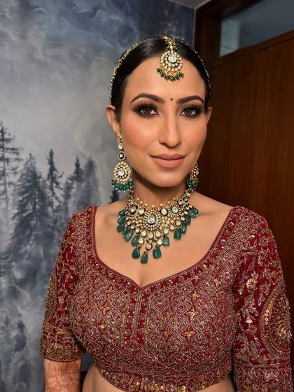 A close-up of this bride's royal look. I paired a brown smoked-out eye with a hint of rose gold to complement her maroon lehenga and emerald jewelry.