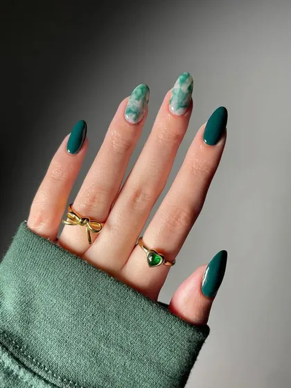An elegant and sophisticated set featuring deep forest green paired with a realistic green marble accent nail on a chic almond shape.