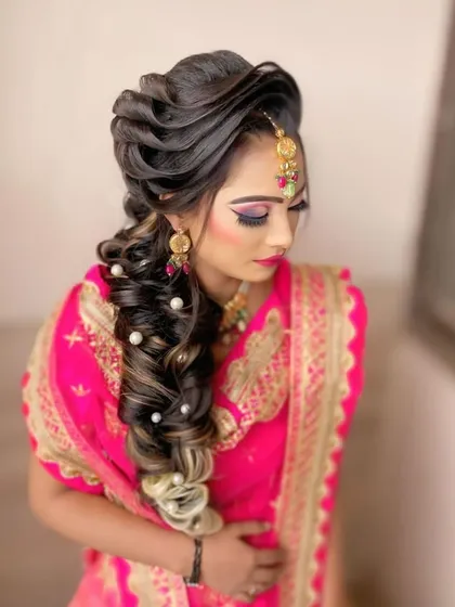 This is another variation of the popular reception braid, with carefully placed pearls and highlights that catch the light. It's a perfect blend of traditional and modern hairstyling.