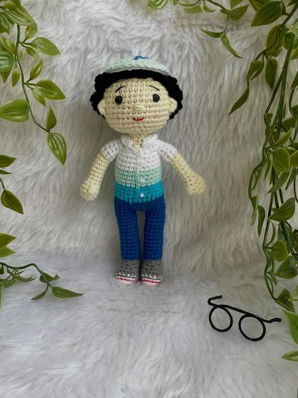 This handsome little boy replica doll features curly hair, a cap, and removable glasses. It’s so fun to create these little details that make each doll a true mini-me.