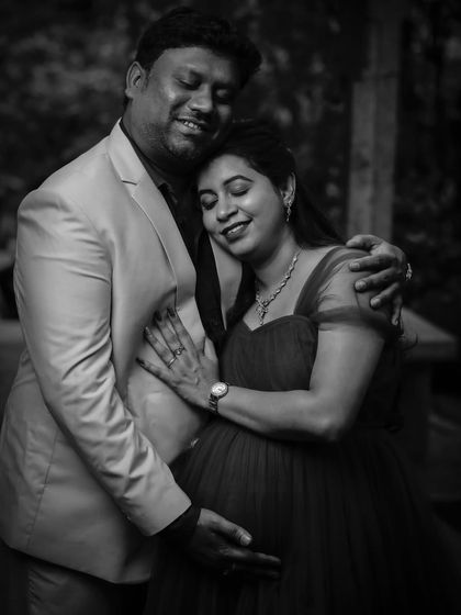 A beautiful black-and-white portrait capturing a quiet, intimate embrace. This style strips away color to focus purely on the emotion and connection between the expecting parents.