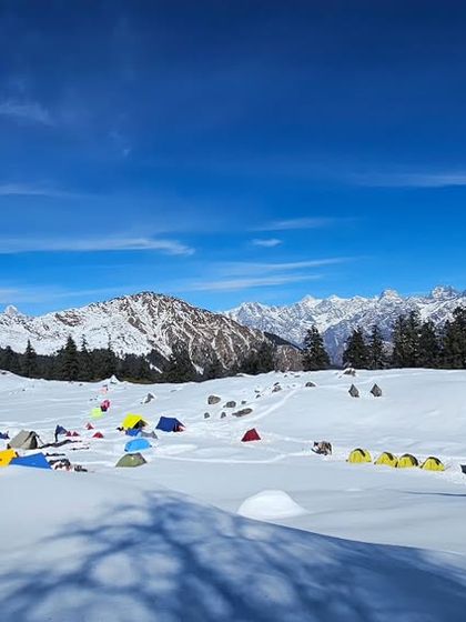 A vibrant campsite against a vast, snowy landscape. Winter camping requires a different level of physical and mental preparedness. I help you build the resilience to not just survive but thrive in cold, high-altitude environments.