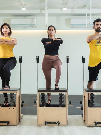 Our instructors demonstrating perfect synchronized form on the Pilates Chairs. We prioritize safety and confidence in every class.