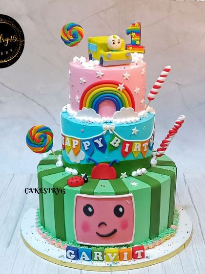 An 8kg, three-tier Cocomelon cake that's a true party centerpiece. It's packed with colorful details, characters, rainbows, and lollipops for a festive first birthday.