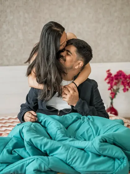 A sweet kiss on the forehead during a relaxed, in-home pre-wedding photoshoot. These moments are pure and heartfelt.