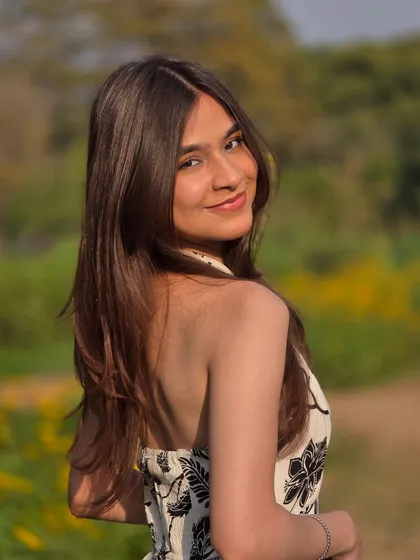 A beautiful portrait taken in a field of yellow flowers. Her over the shoulder smile and the soft background make this a classic, pretty outdoor shot.