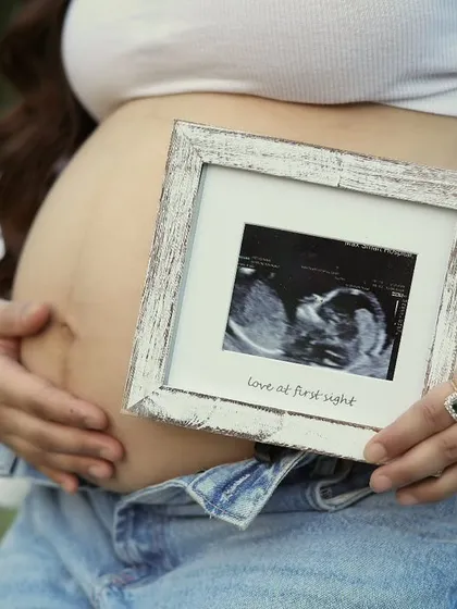 A close-up on the bump, with the mom-to-be holding a framed sonogram picture. It's a beautiful way to say "love at first sight" and a popular shot in our casual maternity sessions.