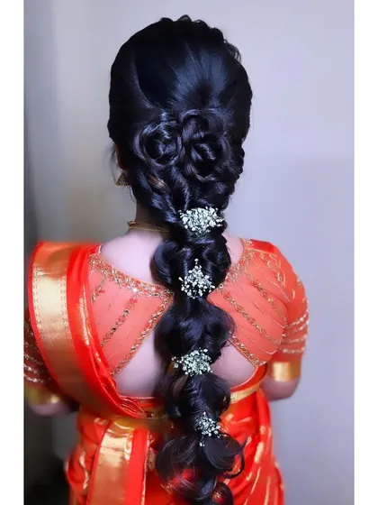 This is a modern take on a bridal braid. I created an intricate, multi-layered braid with bubble and floral details, finished with delicate baby's breath accessories for a unique and sophisticated look.