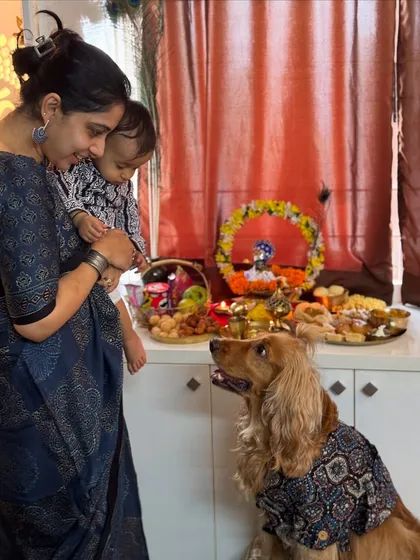 A sweet moment between mother, son, and fur-son during the Janmashtami puja.