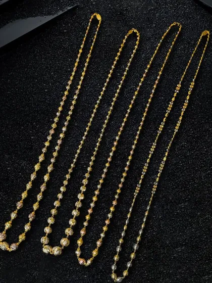 Here, I've arranged four distinct chain styles on a black textured surface. The contrast makes the gold pop, and the diagonal layout guides the viewer's eye across each piece.