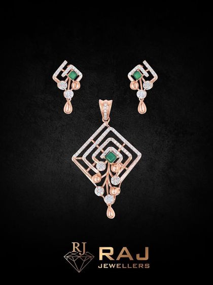 This geometric pendant set features a central emerald-cut green stone within a diamond-shaped frame. The clean lines and dangling elements create a modern and sophisticated look.