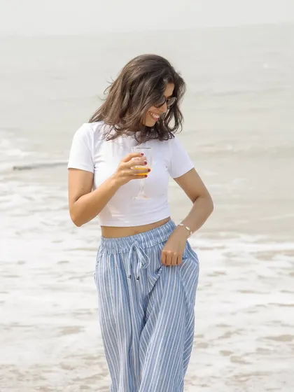 A candid, smiling shot from the beach picnic series. This photo captures a moment of genuine joy, making the content feel relatable and authentic while showcasing a casual summer outfit.