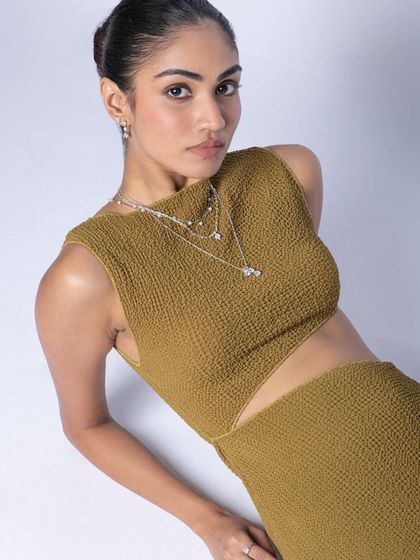 A high-angle portrait for a fashion jewelry brand. The pose is designed to draw attention to the accessories while maintaining a modern, chic vibe.