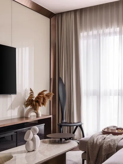 Another view of the TV area, highlighting the clean lines and the contrast between the glossy panel and the soft, matte textures of the sofa and curtains.