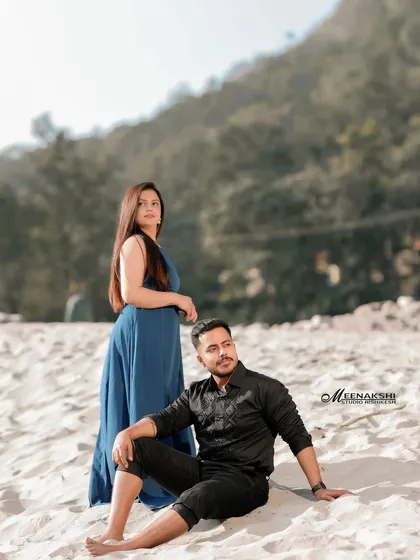 A relaxed pre-wedding photo of a couple posing on the sandy banks of the Ganga. The natural setting and their comfortable posture reflect a casual and authentic love story.