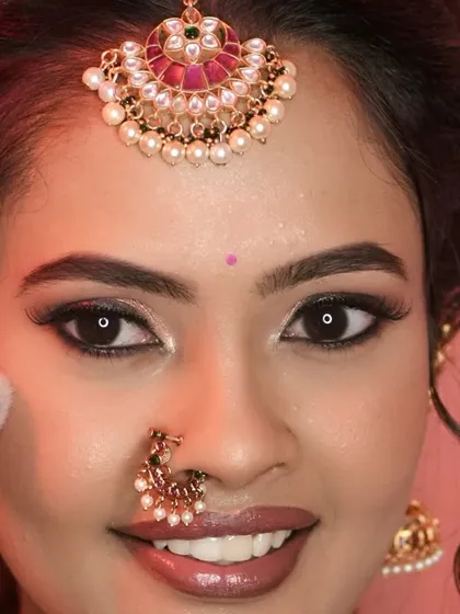A close up of this bride's beautiful smile and makeup. The focus is on the clean, defined eye makeup with a sharp wing and a perfectly applied nude lipstick.
