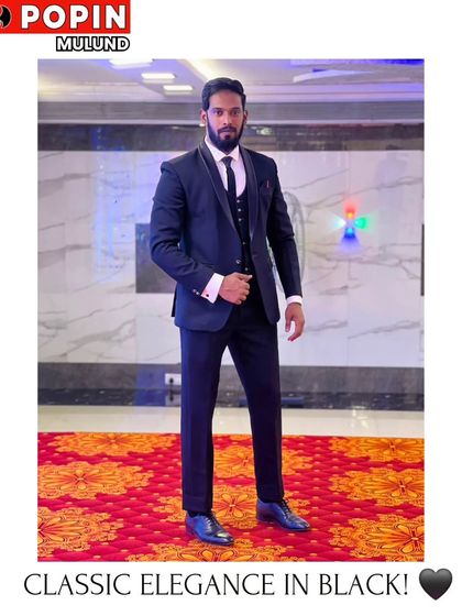 A full-length shot of a client in a classic black three-piece suit. The fit is impeccable, creating a powerful and elegant silhouette for a formal wedding reception.