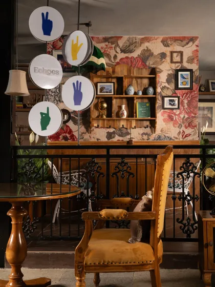 The unique signage for Echoes, featuring hand gestures from sign language, is a nod to the café's inclusive mission. It hangs in a space filled with vintage furniture and layered textures, blending purpose with personality.