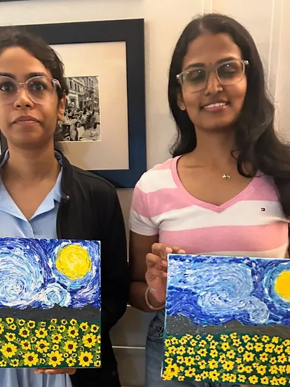 Two more artists with their completed 'Starry Night' and sunflower field paintings, ready to take their masterpieces home.