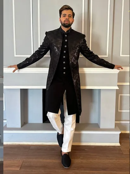 A full-length shot of the black sequined sherwani, showing its commanding presence. This is a perfect outfit for a sangeet or reception night.