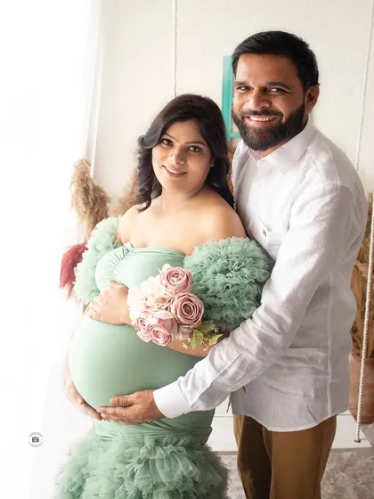 A happy couple portrait from a maternity photoshoot. The combination of the mint green gown and soft flowers is perfect for a spring or summer feel.