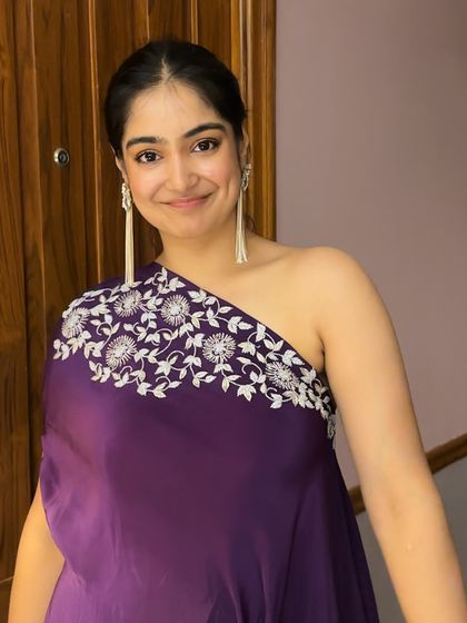 A close-up of my wedding guest look. The one-shoulder dress features delicate white embroidery, paired with long tassel earrings for a contemporary and stylish vibe.