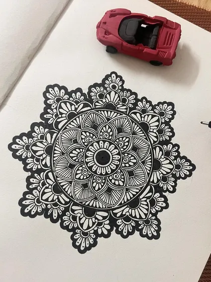 This is a classic black and white mandala, created with fine-liner pens. My tutorials break down how to draw these intricate patterns, from the basic grid to the final detailed petals and shapes.