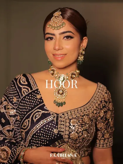 A beautiful bandhani lehenga from Faabiiana, styled with elegant polki and emerald jewellery. The draping of the dupatta is key to this traditional look.