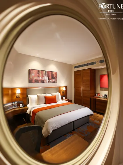A creative perspective of our well-appointed room, reflected in a circular mirror. This view captures the harmony of the design, from the comfortable bed to the curated artwork.