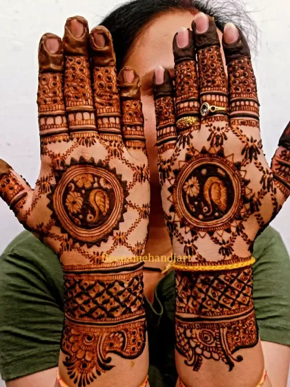 A client proudly displaying her intricate peacock mandala mehandi.