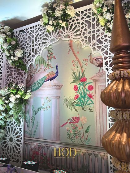 A close-up of the Pichwai art backdrop, showcasing the hand-painted details of peacocks and birds that bring a unique artistic and cultural element to the stage.