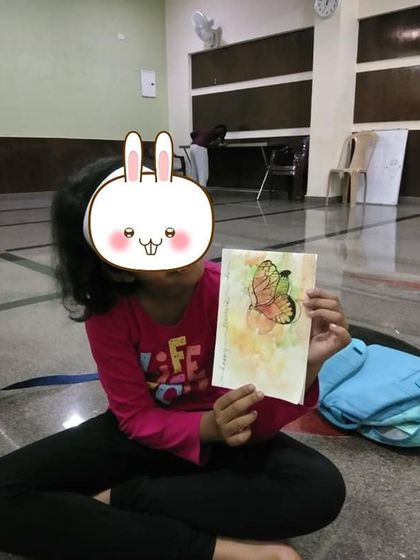 A happy student from one of my workshops, holding up her delicate butterfly painting. It’s so rewarding to see them learn new techniques and feel proud of their work.