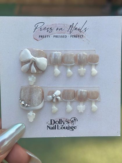 Another adorable press-on toe nail set with 3D bows and a pearly white and nude color scheme.