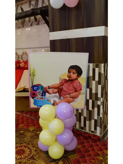 Personalized photo stands are a great way to decorate the party space. This one features a cute picture of the birthday girl, adding a personal and sweet touch to the venue.