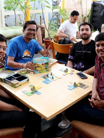 A group proudly shows off their copy of 'Kingdomino' after a game. It's always great to see people discovering new favorite board games here.