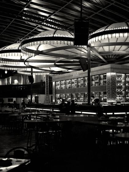 A moody, low-light shot of the bar, where the illuminated canopies appear to float in the darkness. This demonstrates the power of custom lighting to transform a space.