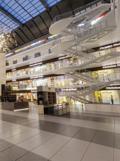 A sculptural white staircase connects the different floors of the mall, acting as a central feature in the main atrium.