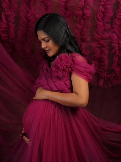 This studio shot showcases the incredible texture and flow of my magenta ruffled maternity gown. The rich color and voluminous fabric create a dramatic and artistic portrait for your pregnancy photoshoot.