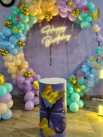 A detailed shot of the butterfly-themed party plinth and the pastel balloon arrangement.