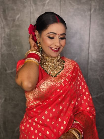 A candid shot of the reception bride, her joyful expression captured perfectly. The red saree and traditional jewellery look stunning.