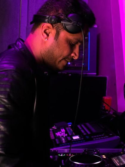 A DJ focused on his mix at the Radisson Blu NYE party. I ensure top-tier technical gear and support for all my performing artists.