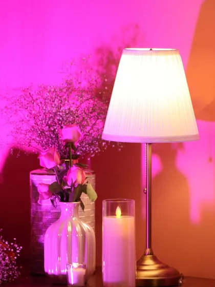 Soft, romantic lighting is key to setting the mood. A simple table lamp, a glowing candle, and delicate baby's breath create an intimate and warm corner within the grand 'Anant' setup.