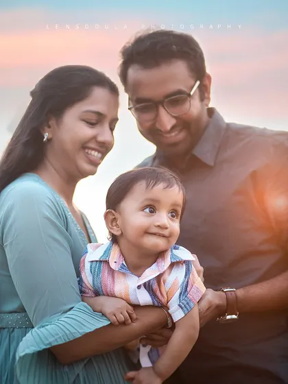 A close-up of a happy family, with the baby looking curiously at the world. The golden light adds a warm and magical glow to this beach portrait.