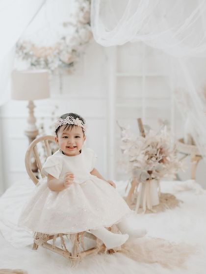 A bright and airy portrait of a little princess. The all-white theme with delicate details creates a look of pure elegance and innocence.